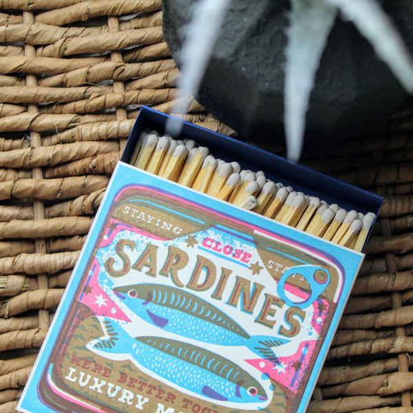 Letterpress-printed matchbox featuring a playful sardines graphic with the text 'We're Better Together.' A quirky, fun design for lighting candles or gifting.