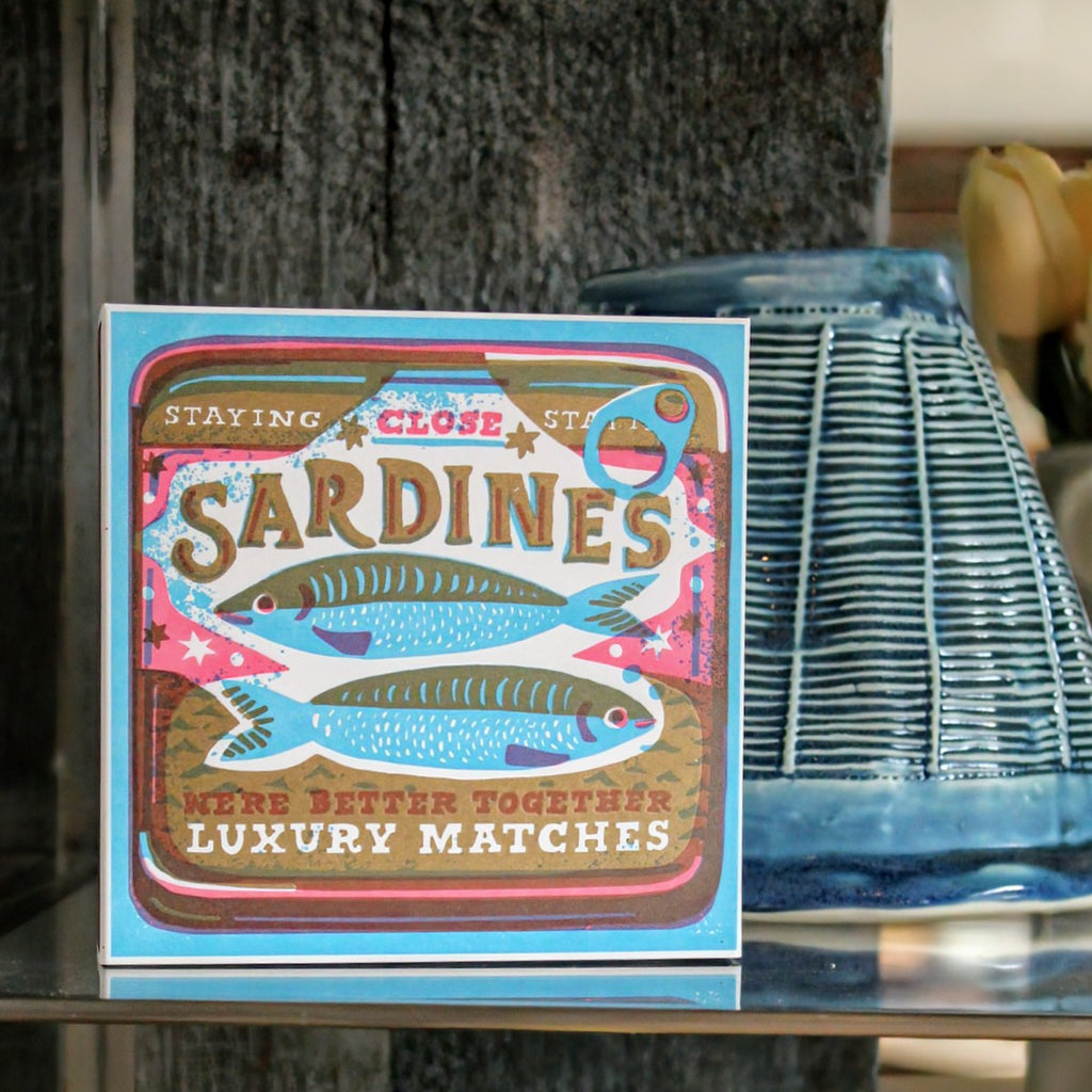 Letterpress-printed matchbox featuring a playful sardines graphic with the text 'We're Better Together.' A quirky, fun design for lighting candles or gifting.