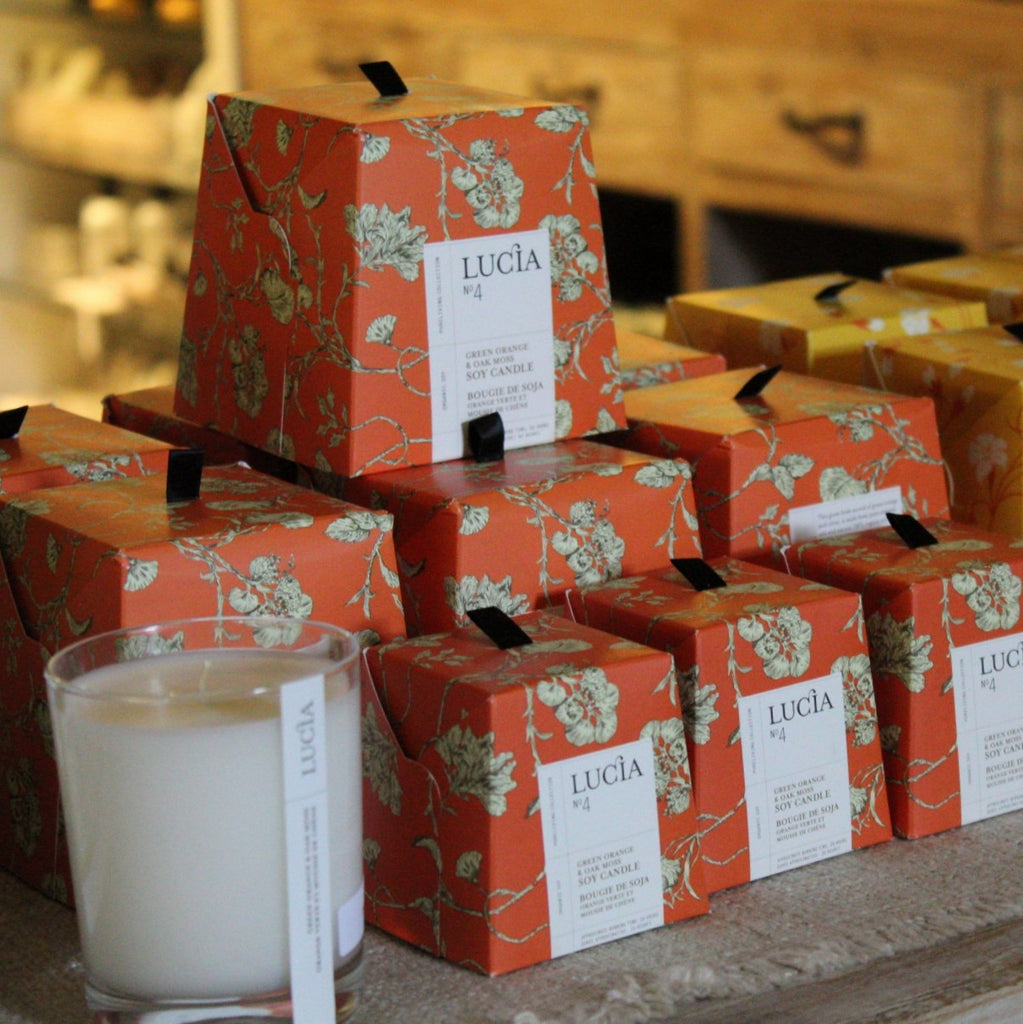 Multiple boxes of Green Orange & Oak Moss  Soy Candles stacked on top of each other