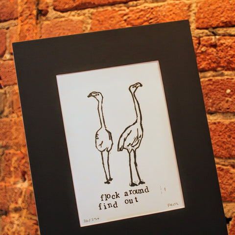 Two flamingos and the bold text “flock around and find out” 