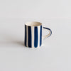 Mug with blue and white stripes on a light gray background