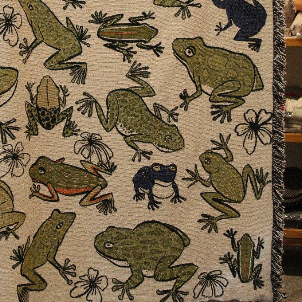 Detail of Fringed throw blanket with colorful assorted frogs